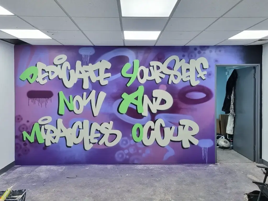 a purple wall with white text and green text